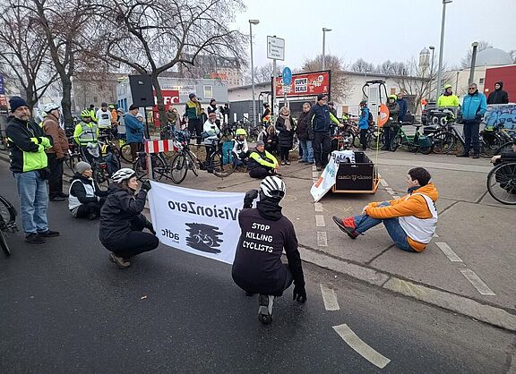 Menschen bei einer Mahnwache für einen getöteten Radfahrer auf der Straße