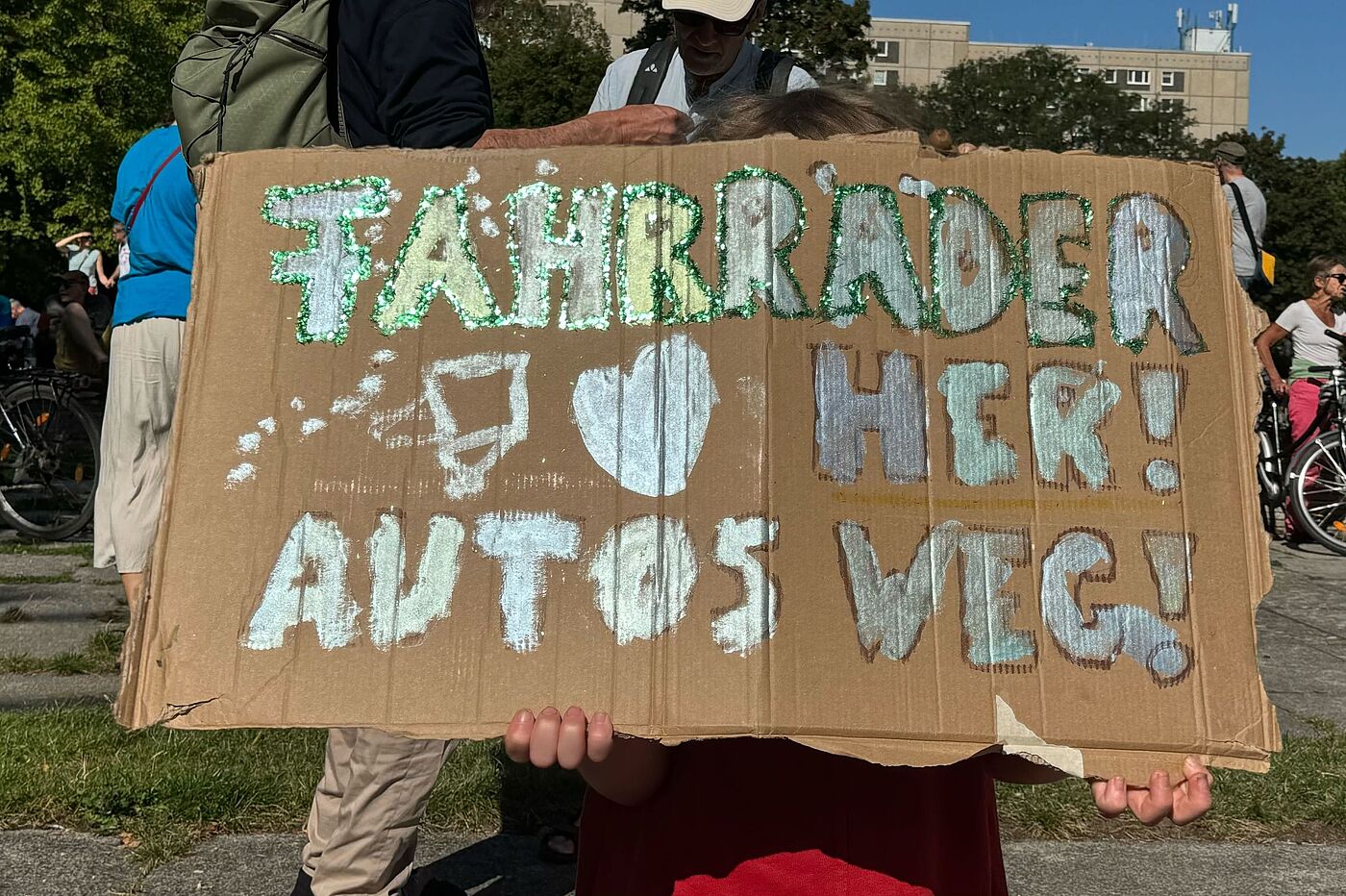 Kidical Mass Klimastreik 20.09.2025 Ein Kind hält ein Schild hoch auf dem steht: Fahrräder her, Autos weg!