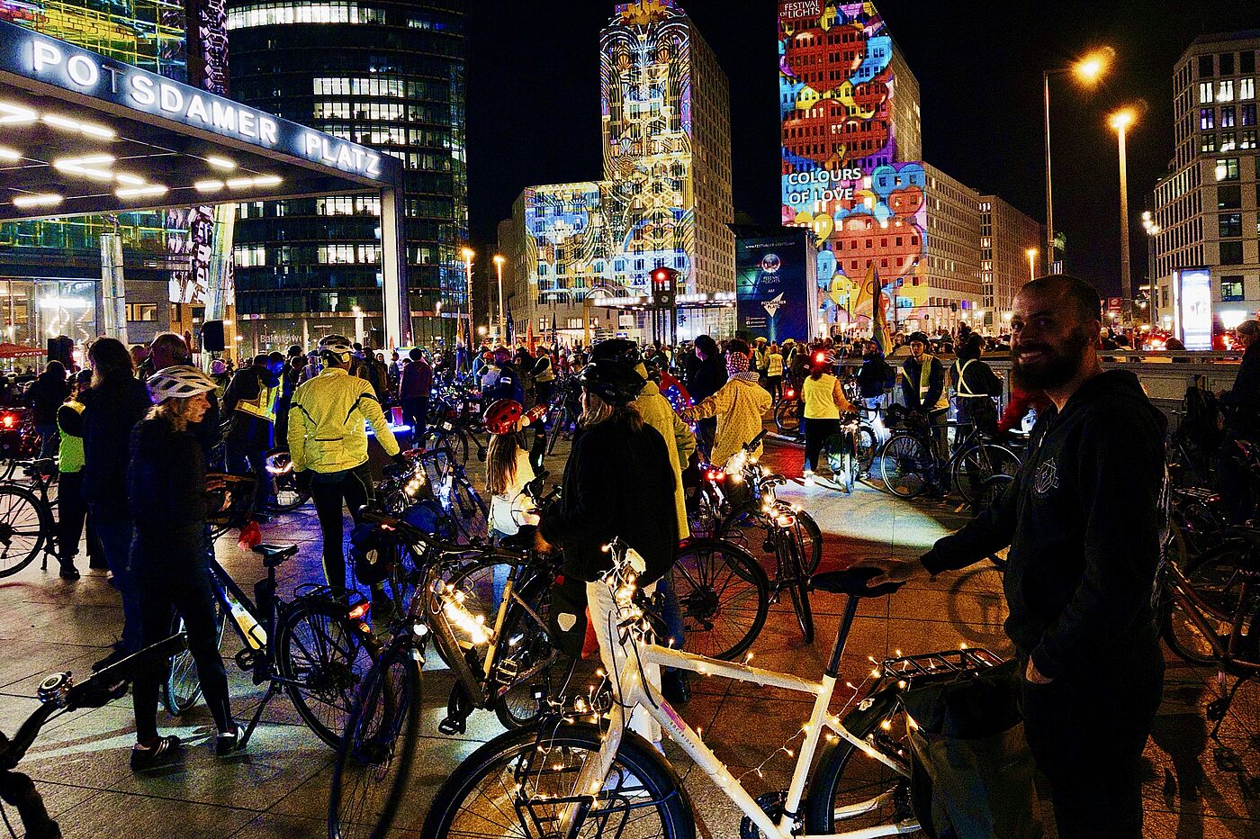Start der Lichterfahrt 2026 am Potsdamer Platz: Bunt beleuchtete Gebäuden und mit Lichterketten geschmückte Fahrräder