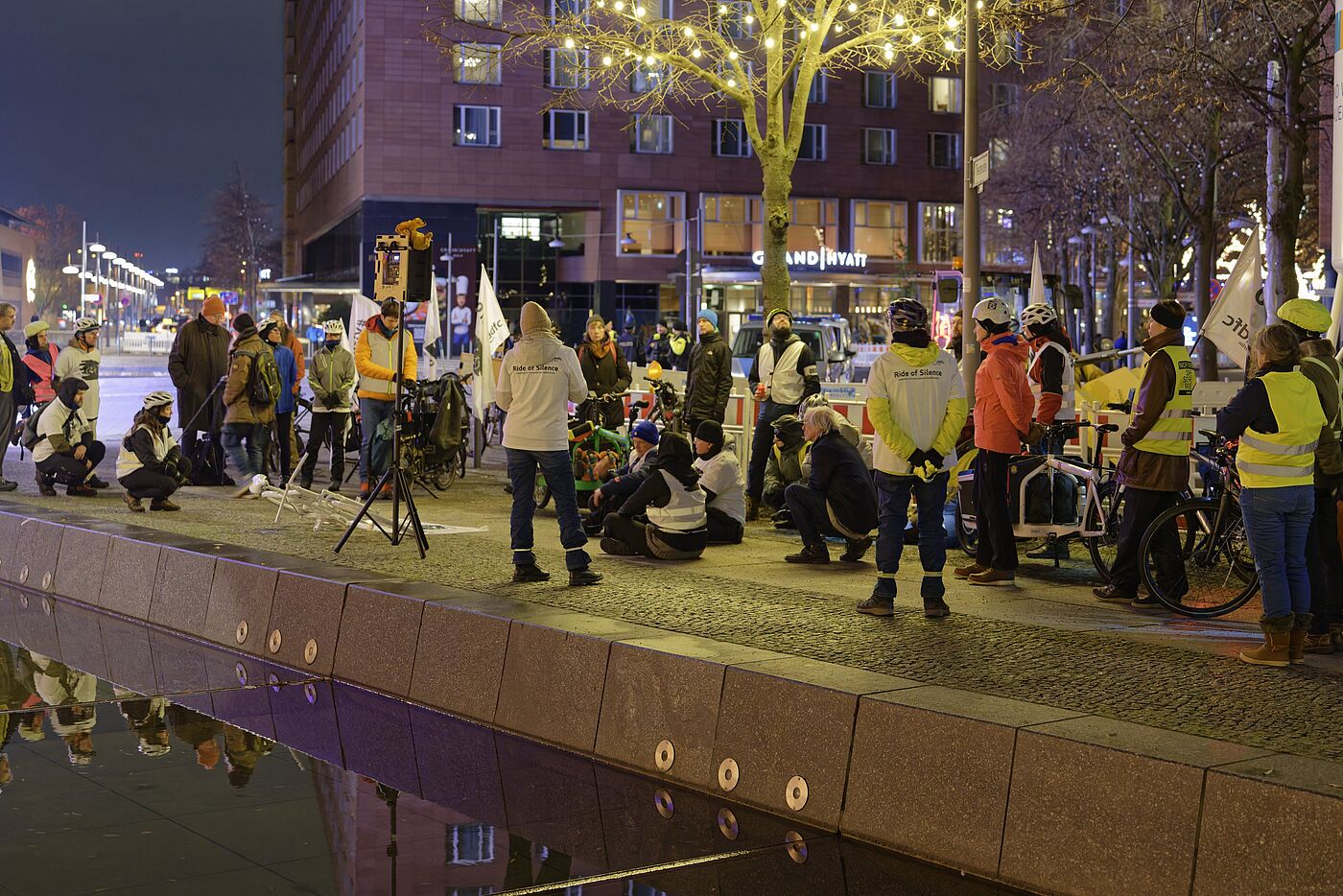 Menschen mit Warnwesten stehen bei einer Mahnwache